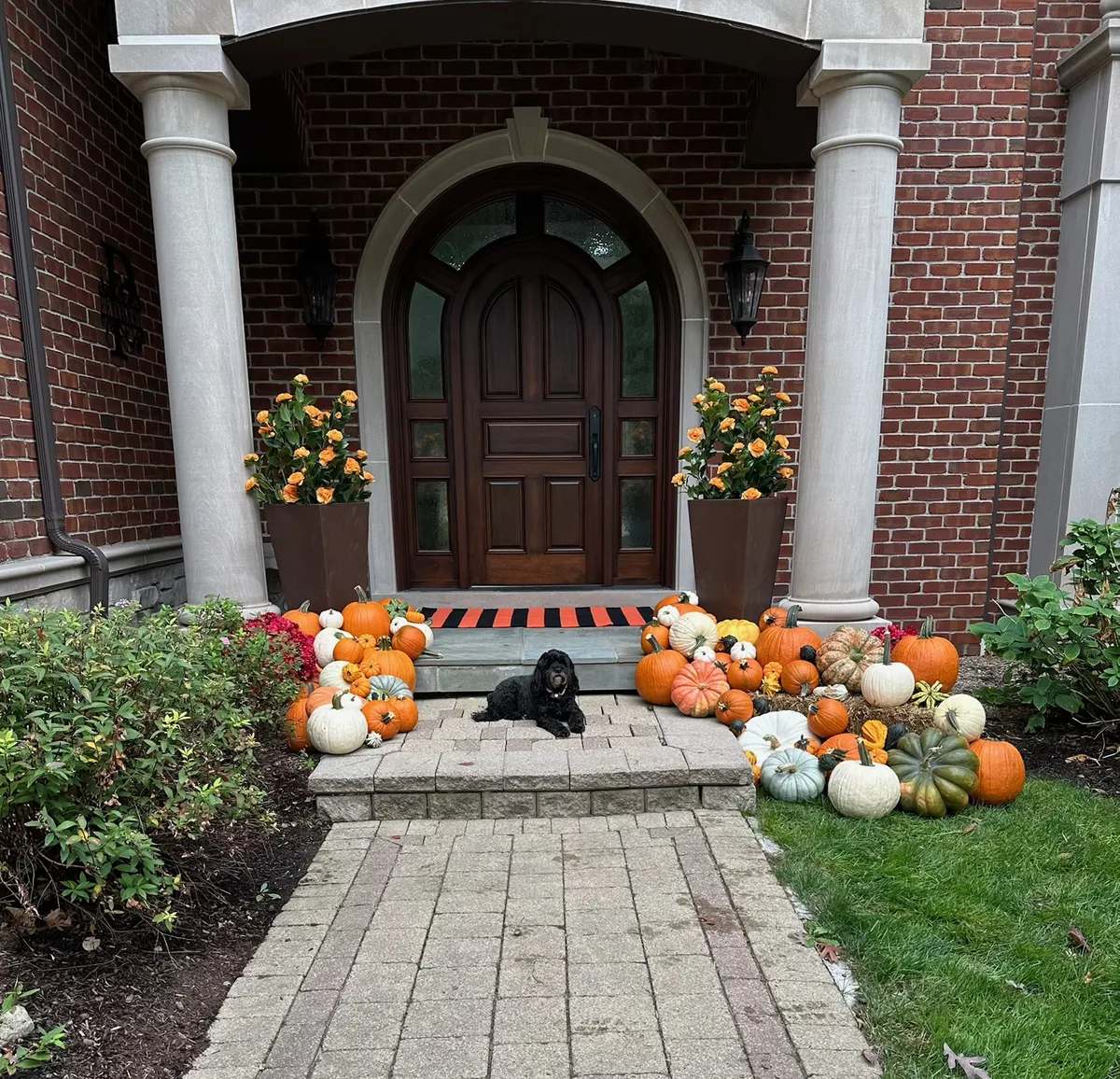 Fall porch decorating service with pumpkins and arched door in Birmingham MI