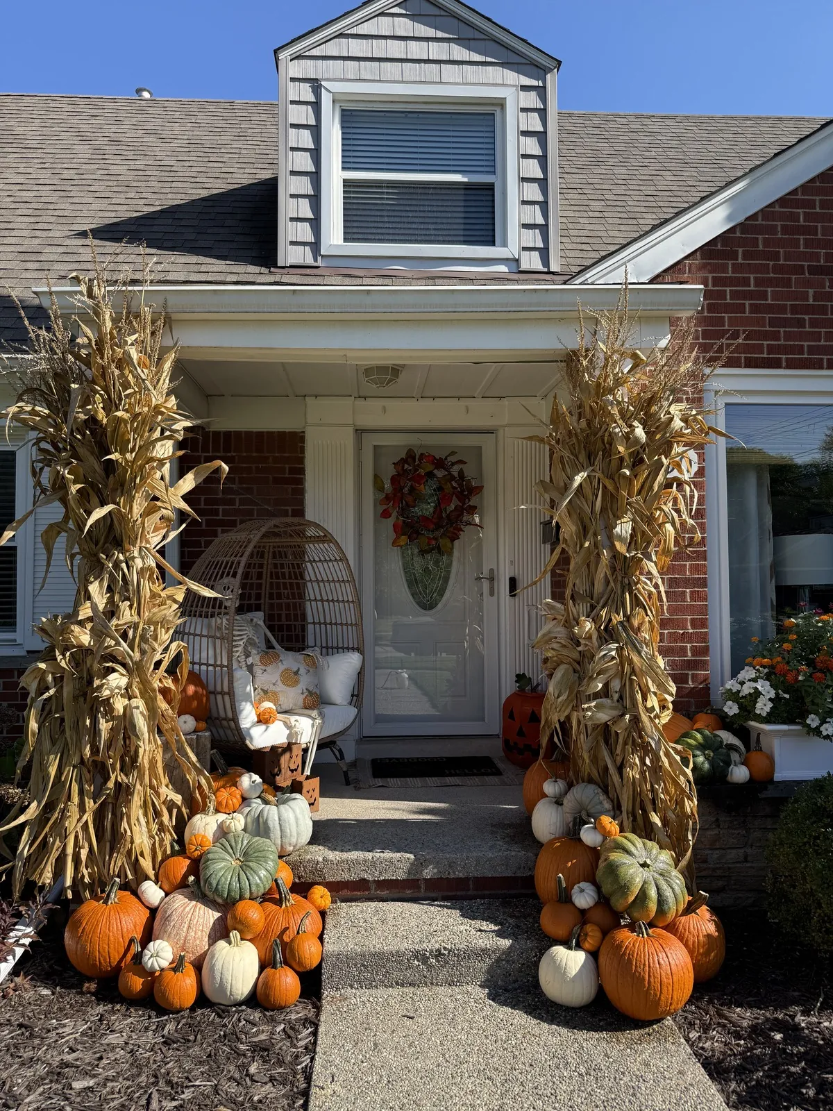 Fall porch decorating with towering corn stalks and heirloom pumpkins on a Metro Detroit MI front porch
