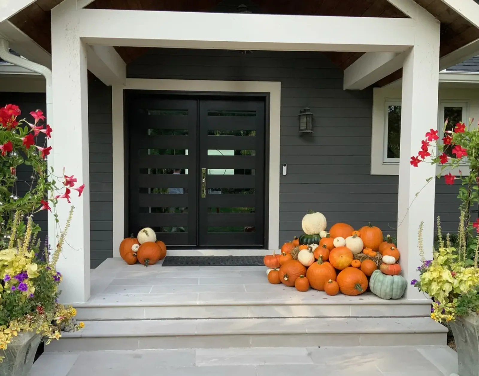 Pumpkin display service with colorful planters on modern porch in West Bloomfield Township MI
